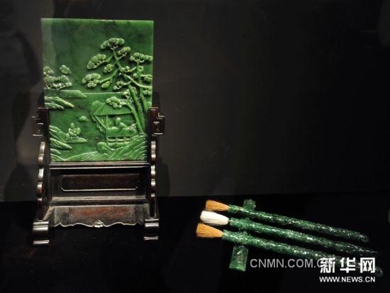 这是11月29日在台北历史博物馆拍摄的碧玉清秋高任图插屏（左）和翠玉龙纹组笔及镇尺。