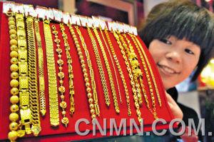 1月30日，山东聊城市一家大型商场金店的工作人员在展示黄金手链。